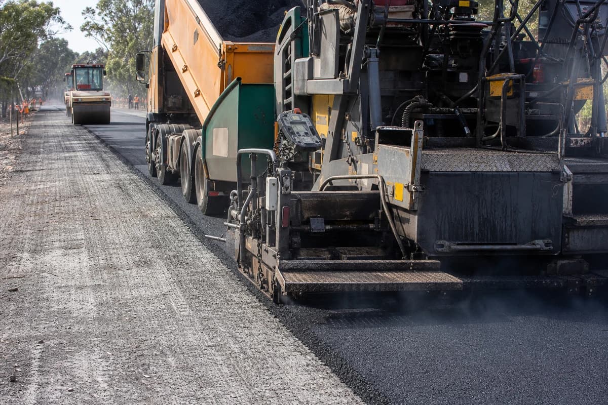 Pavement contractor NSW asphalt works with paver and roller on an access road base course