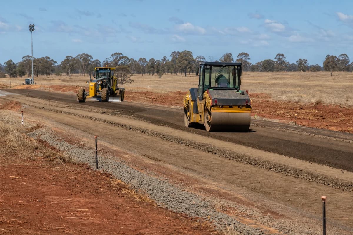Roadworks Badgerys Creek yellow roller and grader forming industrial access road on Cumberland Plain near Bradfield NSW Australia
