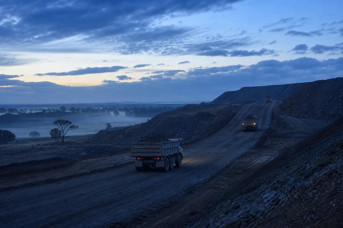 Earthworks contractor NSW dawn haul corridor with dump trucks moving cut material on a temporary track