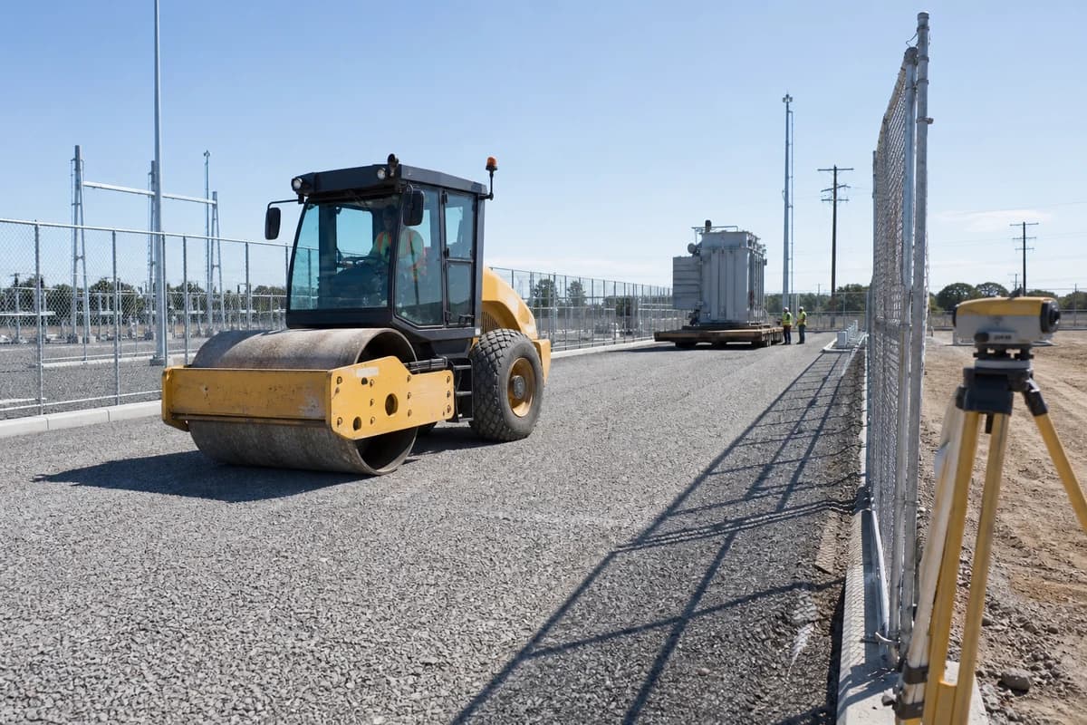 Grid connection civil works NSW substation pad under compaction with survey control near a fenced compound