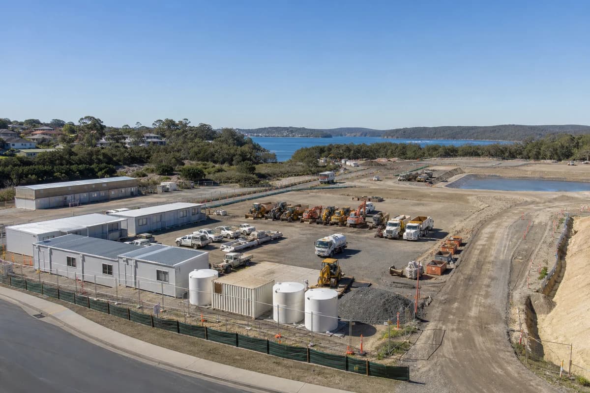 Organised NSW civil site compound with plant lined up and sediment controls visible under clear morning light