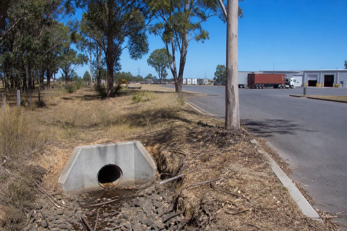 Culvert installation NSW headwall and overland flow channel beside an industrial yard access road in New South Wales, Australia