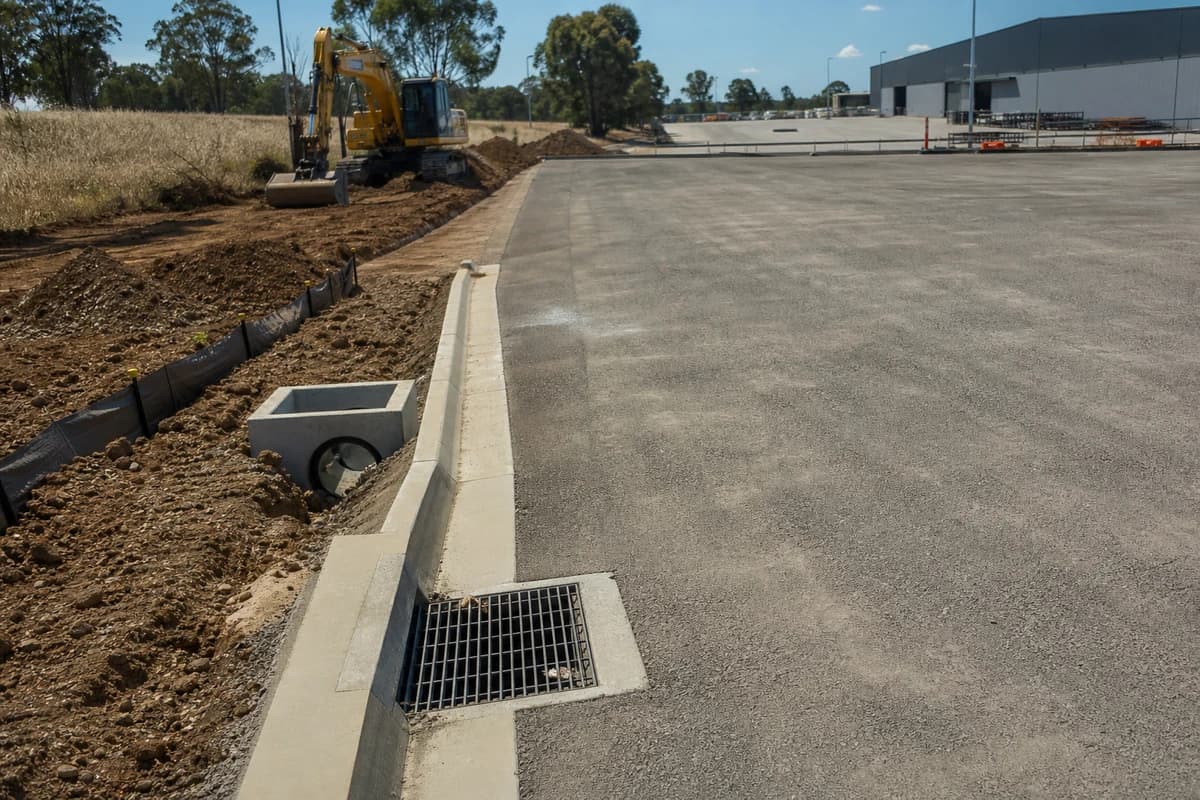 Industrial yard drainage NSW hardstand apron with stormwater pits and kerb inlet during civil works in New South Wales, Australia