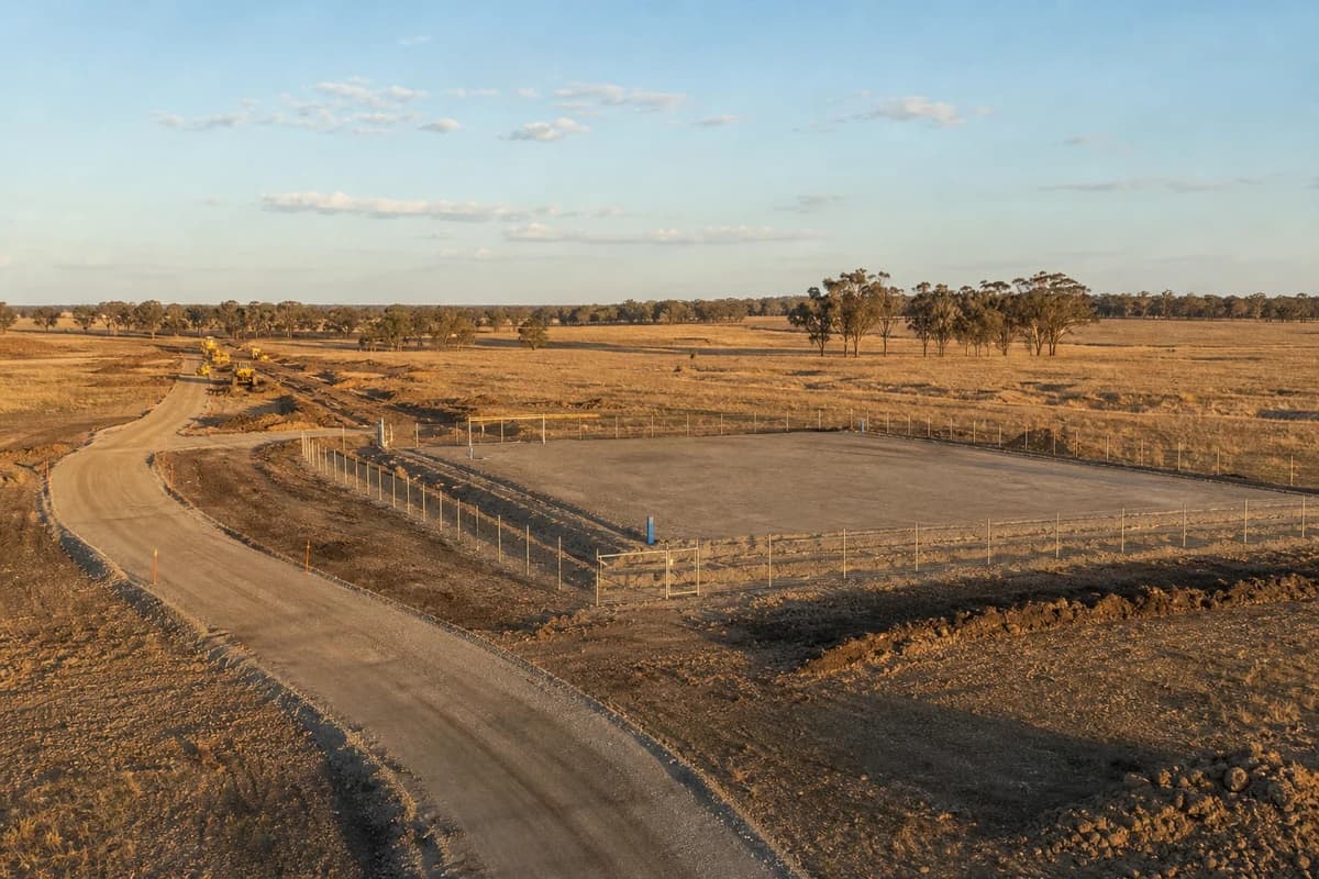 Renewable access roads leading to a fenced grid connection civil works compound pad across NSW REZ farmland at late afternoon