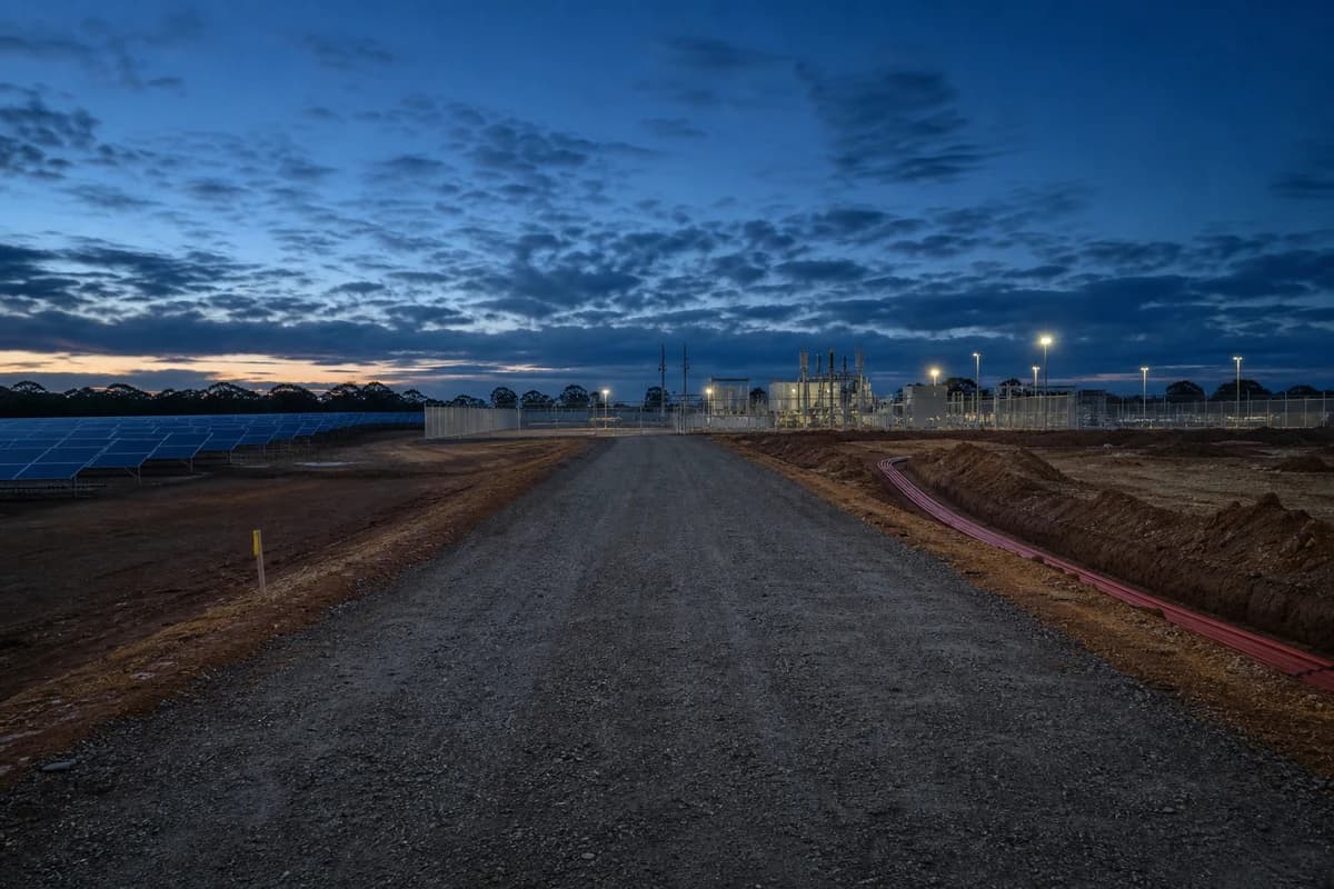 Renewable access roads and grid connection civil works toward a fenced substation pad at dusk on a NSW solar farm