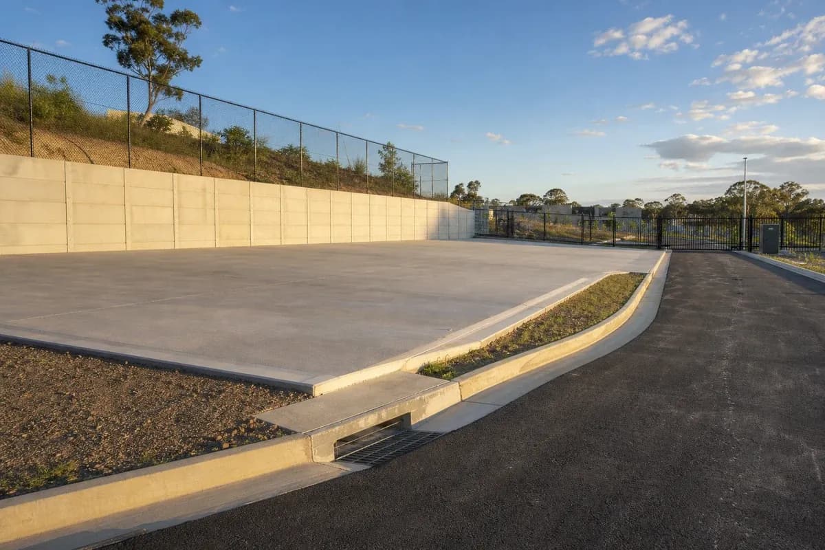 Structural civil works NSW completed hardstand with retaining wall, access road, and stormwater kerb on an industrial estate